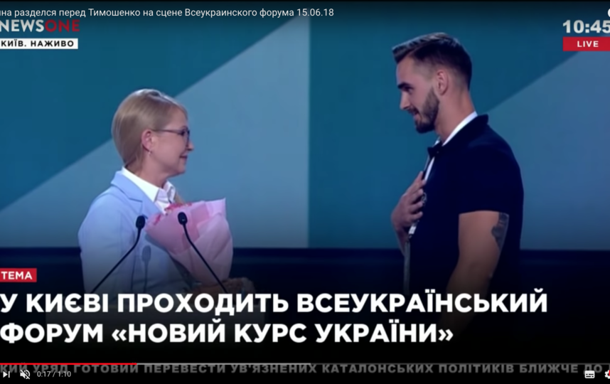 На кадрах видно, что молодой мужчина поднимается на сцену и вручает Тимошенко цветы. Фото Скриншот Youtube