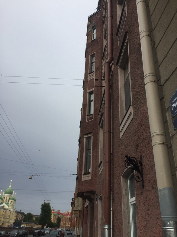 На одной из улиц Петербурга часть фасада здания обрушилась на машину. 