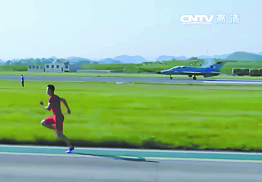 Серебряный призёр чемпионата мира в эстафете 4&#215;100 Чжан Пэймэн соревновался в скорости с истребителем FTC-2000. На дистанции 100 м сильнее оказался человек, обогнавший самолёт на долю секунды. Фото скриншот с видео CNTV