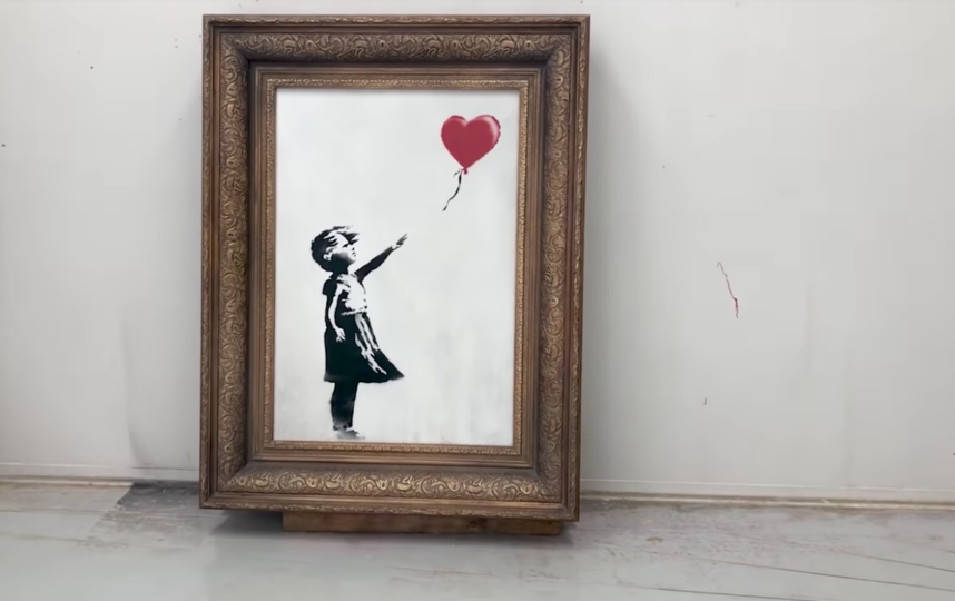 Бэнкси уничтожил свою картину, практически проданную на аукционе более чем за миллион фунтов. Фото Канал banksyfilm, Скриншот Youtube