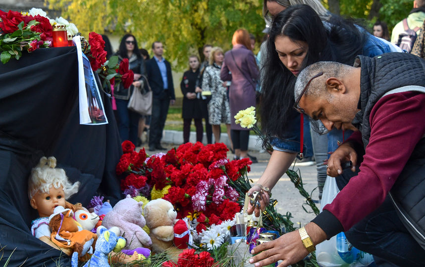 Люди приносят цветы к зданию политехнического колледжа, чтобы отдать дань памяти погибшим. Фото AFP