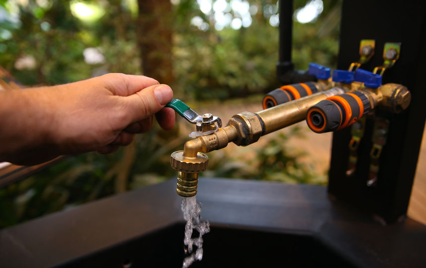 Через дождевой водопровод вода поступает в оранжерею, и её можно наливать из обычного крана над кирпичным колодцем. Фото Василий Кузьмичёнок