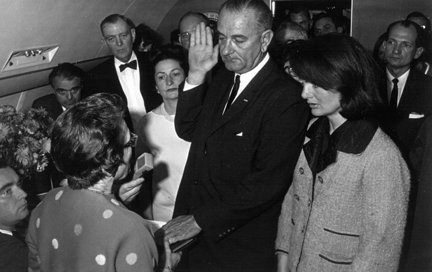 Джеки, в запачканном кровью розовом костюме, в то время как Джонсон даёт присягу при вступлении в должность президента. Фото Getty