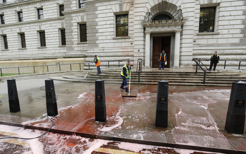 В результате инцидента около 1800 литров красной пищевой краски было вылито у главного входа в здание. Фото AFP