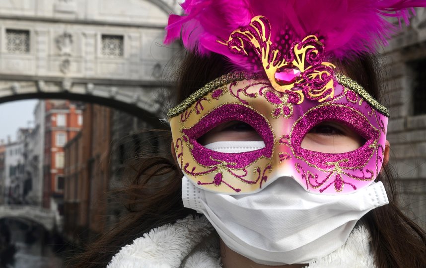 Так выглядит типичный посетитель Венецианского карнавала: под карнавальной маской – медицинская. Фото AFP