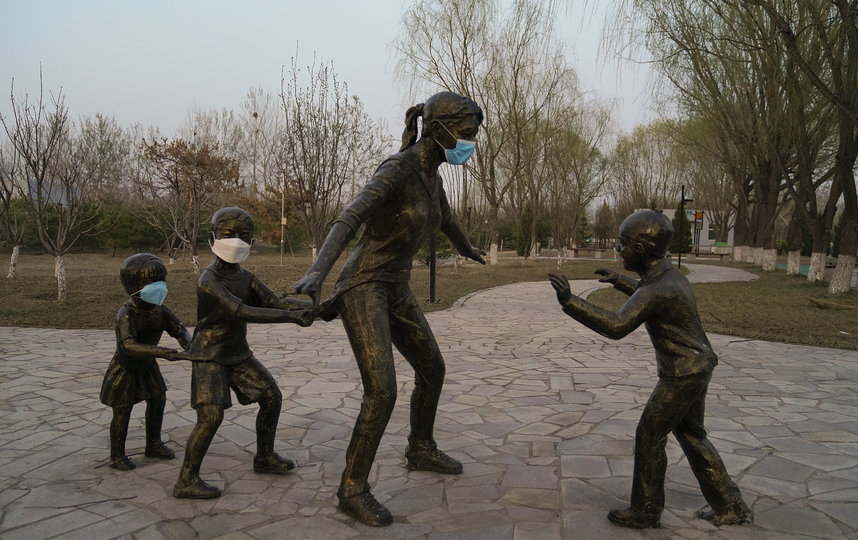 Жители Пекина использовали памятник, чтобы показать важность ношения маски. Фото Getty