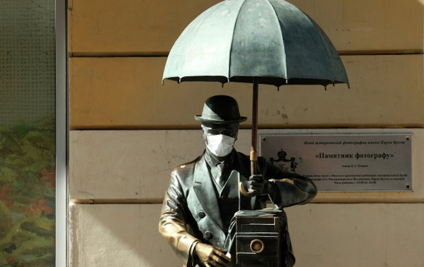 Памятник фотографу с надетой медицинской маской на Малой Садовой улице в Санкт-Петербурге. Фото РИА Новости
