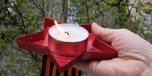 Свеча и георгиевская ленточка в руке жителя Москвы. Свеча и георгиевская ленточка в руке жителя Москвы.