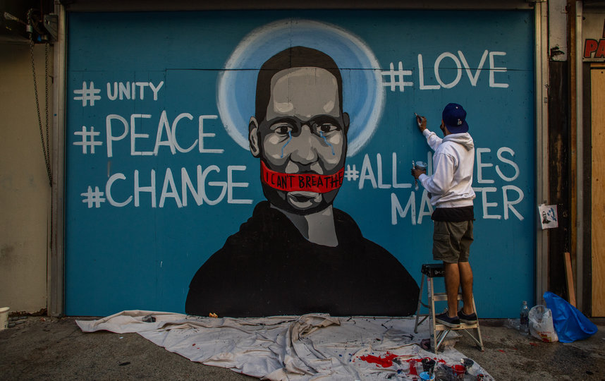 Вокруг портрета на стене также написаны слова "любовь", "единство", "мир", "перемены" и слоган "Все жизни имеют значения". Фото AFP