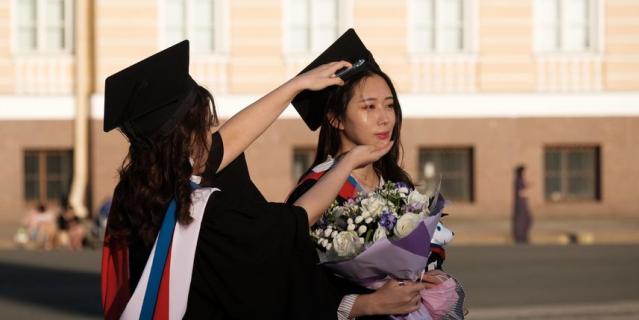 Китаянки в мантиях выпускников фотографировались на Дворцовой площади несколько часов.