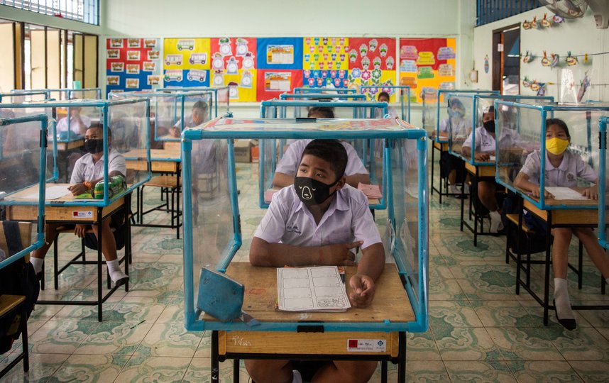 Учеников в Таиланде отгораживают друг от друга специальными кубами, но даже в них они находятся в масках. Фото Getty