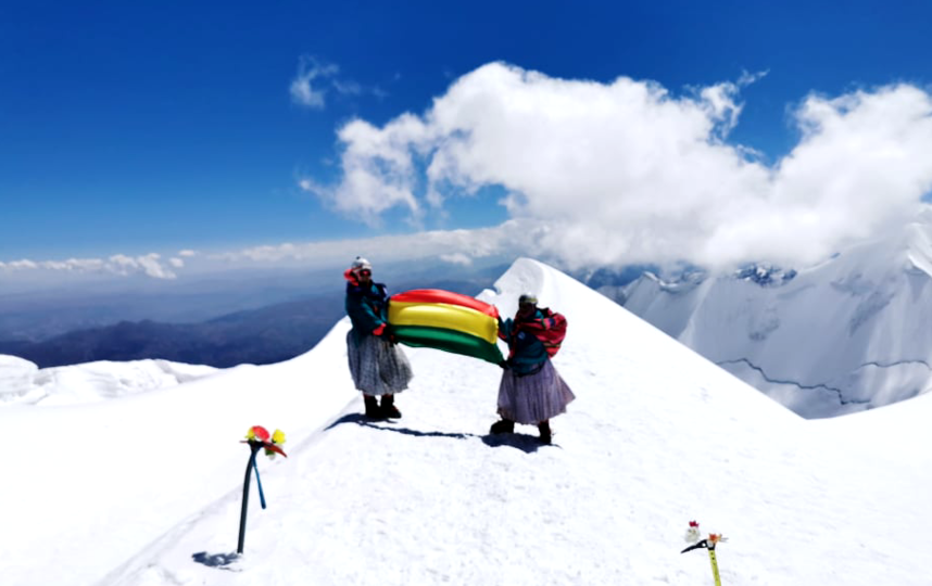 Чолиты поднимают флаг Боливии на покорённой высоте 6439 м – Ильимани. До этого победой женщин стало покорение вершины Мурурата – 5871 м. Фото Instagram: @cholitasescaladoras