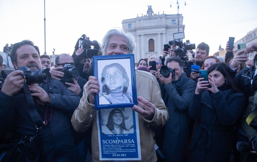 Старший брат Эмануэлы Пьетро на площади Святого Петра в Ватикане. Он держит фотографию сестры – и продолжает бороться за то, чтобы мир узнал правду о том, что с ней произошло. Фото Getty