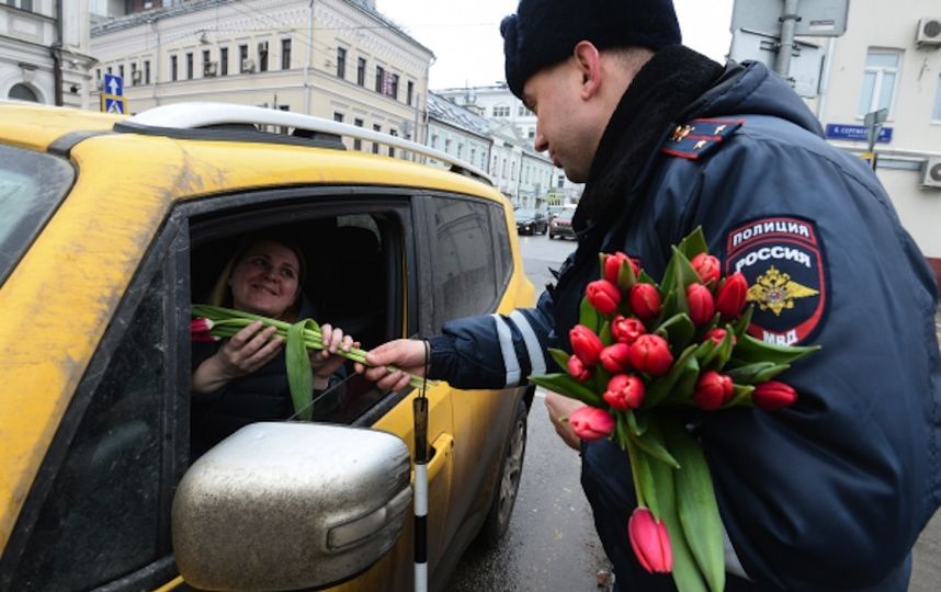 Сотрудник полиции поздравляет женщину с 8 марта. Фото РИА Новости